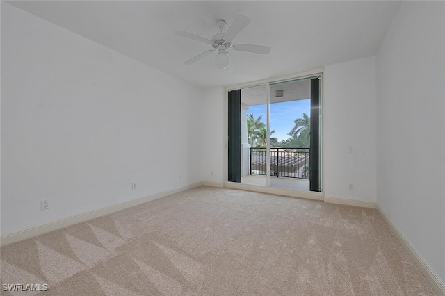 carpeted empty room featuring ceiling fan and floor to ceiling windows