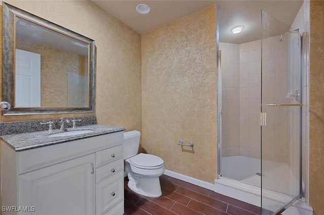 bathroom featuring vanity, toilet, and a shower with shower door