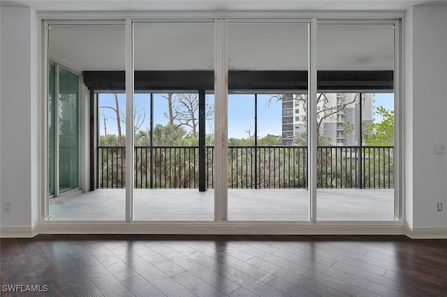 doorway to outside with expansive windows and dark wood-type flooring