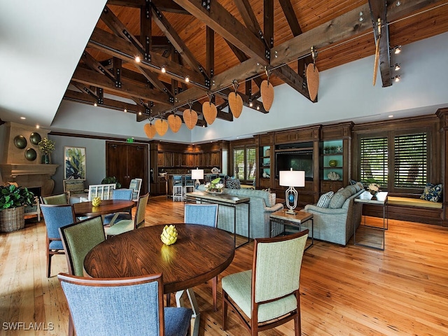 dining space featuring high vaulted ceiling, beamed ceiling, light hardwood / wood-style floors, and wooden ceiling