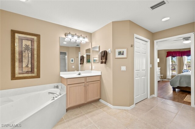 bathroom featuring a bath, tile patterned floors, ceiling fan, and vanity