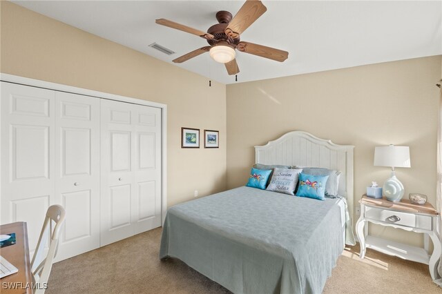 carpeted bedroom with ceiling fan and a closet