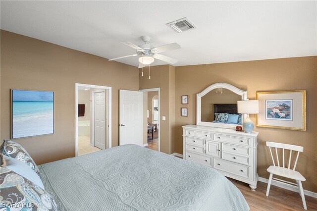 bedroom featuring ceiling fan, ensuite bathroom, and light hardwood / wood-style floors