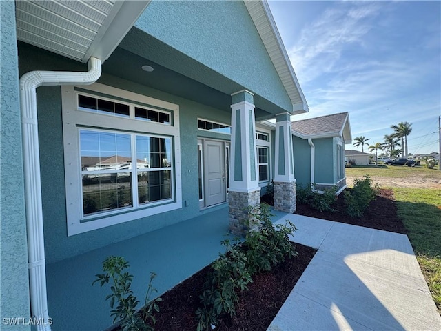 view of side of home featuring stone siding and stucco siding