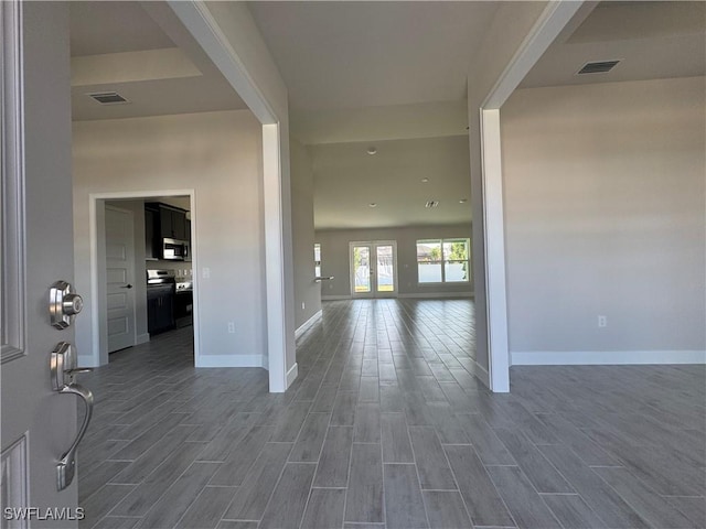 foyer entrance with wood finish floors, visible vents, and baseboards