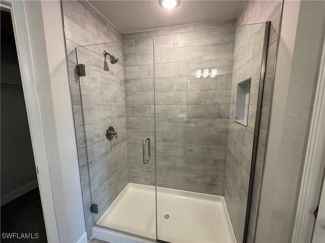 full bath featuring a stall shower and a textured ceiling