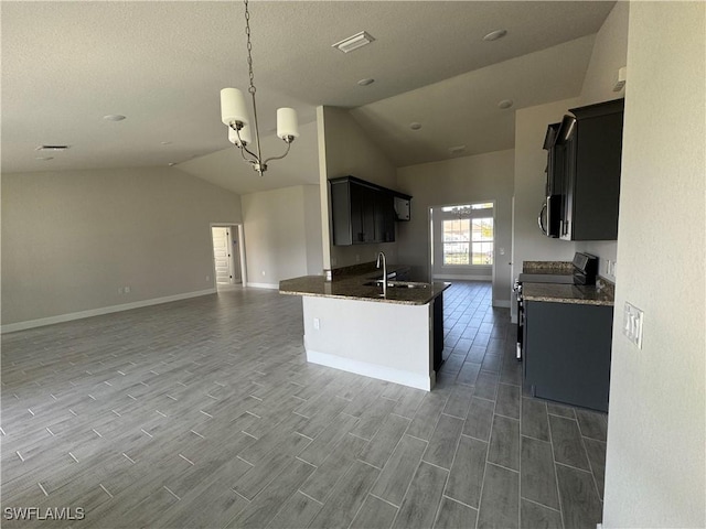 kitchen with lofted ceiling, appliances with stainless steel finishes, open floor plan, pendant lighting, and a sink