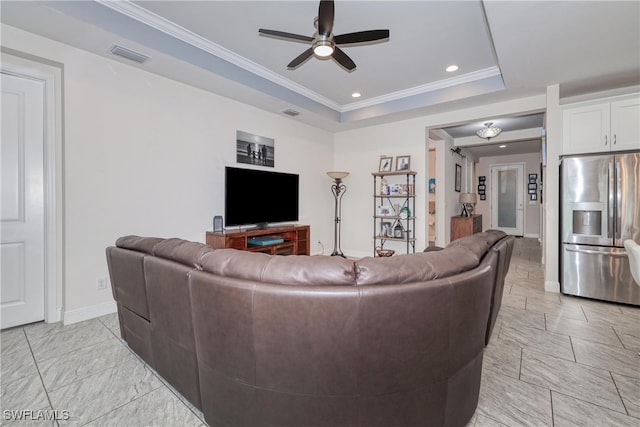 living room with ceiling fan, crown molding, and a raised ceiling