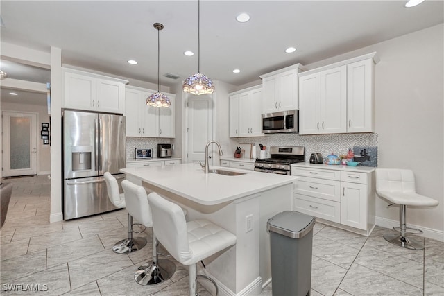 kitchen with sink, white cabinets, hanging light fixtures, and stainless steel appliances