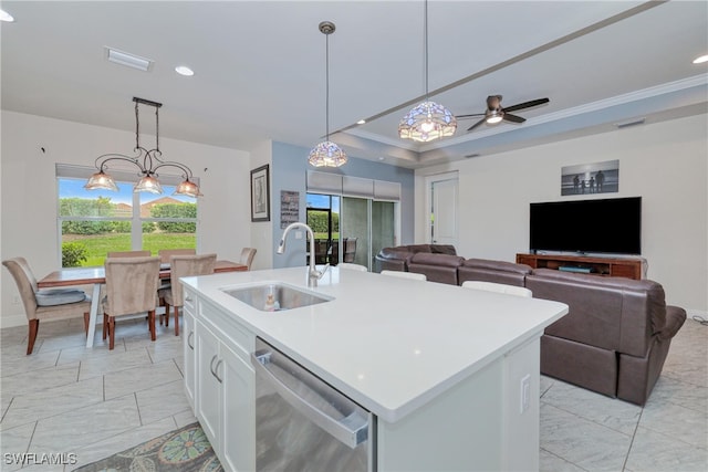 kitchen featuring white cabinetry, hanging light fixtures, stainless steel dishwasher, sink, and an island with sink