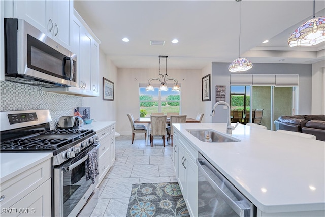 kitchen with sink, an island with sink, white cabinets, and stainless steel appliances