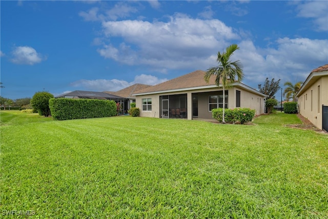 back of property featuring a lawn and a sunroom