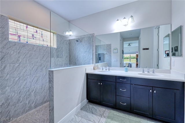 bathroom featuring ceiling fan, tiled shower, and vanity