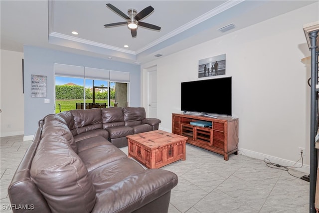 living room with ceiling fan, a tray ceiling, and crown molding