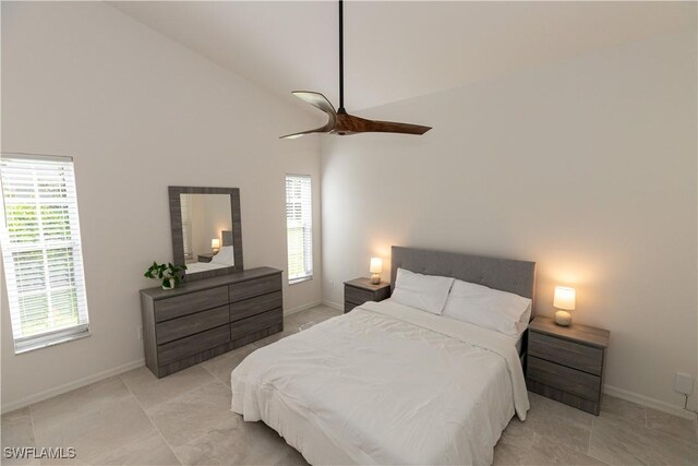 bedroom featuring lofted ceiling, baseboards, and a ceiling fan