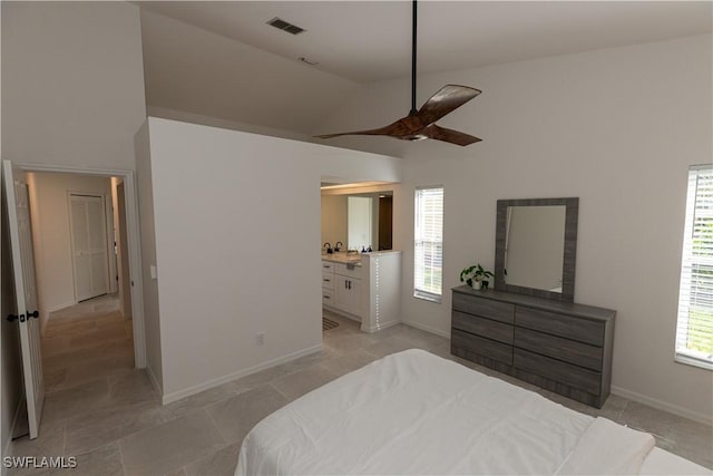 bedroom with lofted ceiling, visible vents, ensuite bathroom, a ceiling fan, and baseboards