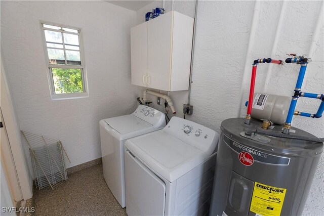 clothes washing area featuring cabinet space, baseboards, a textured wall, washer and dryer, and water heater