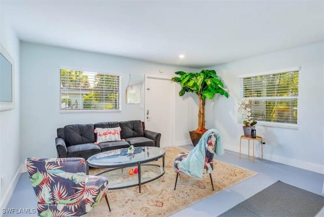 living area with concrete floors and baseboards