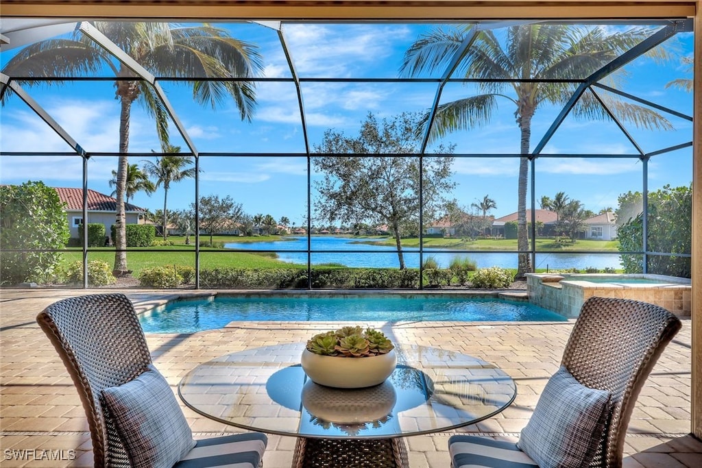 view of swimming pool with an in ground hot tub, a water view, a patio, and a lanai