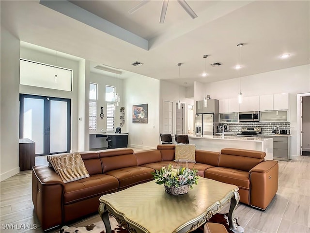 living room featuring sink, french doors, and light hardwood / wood-style floors