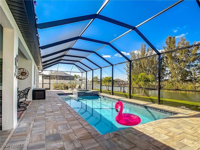 view of pool with a patio, an in ground hot tub, glass enclosure, and a water view