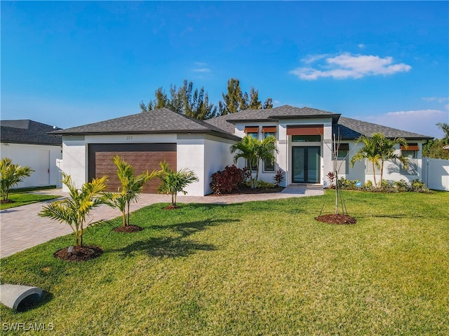 view of front of property featuring a front yard, a garage, and french doors