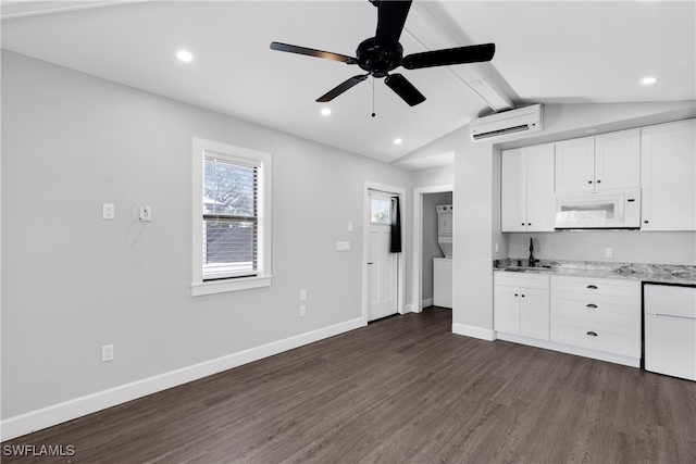 kitchen featuring a wall mounted AC, dark hardwood / wood-style floors, light stone countertops, white cabinets, and lofted ceiling with beams