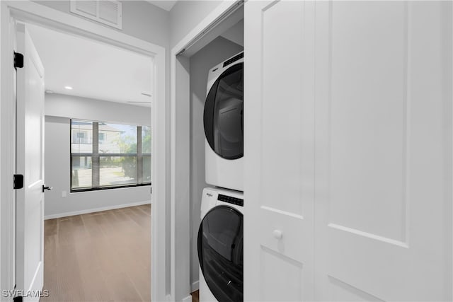 washroom featuring wood-type flooring and stacked washer and dryer