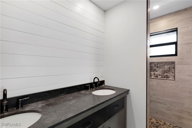 bathroom with vanity and a tile shower