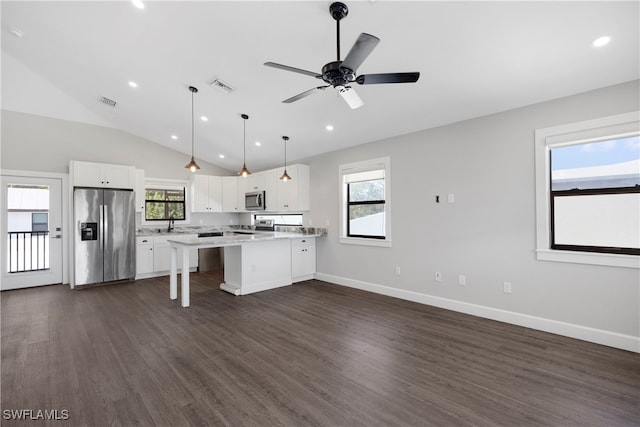 kitchen featuring pendant lighting, white cabinetry, a kitchen bar, and stainless steel appliances