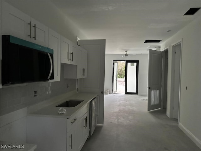 kitchen featuring stainless steel dishwasher, ceiling fan, backsplash, sink, and white cabinetry