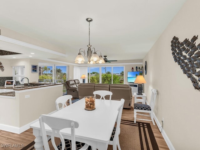 dining space with a chandelier, a healthy amount of sunlight, and light hardwood / wood-style flooring