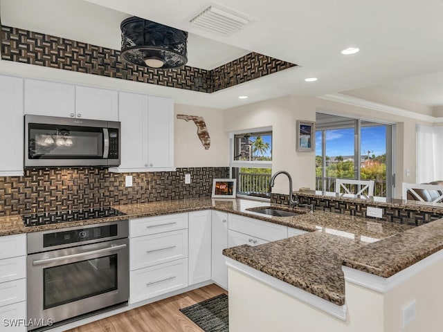 kitchen with sink, white cabinetry, a tray ceiling, and appliances with stainless steel finishes