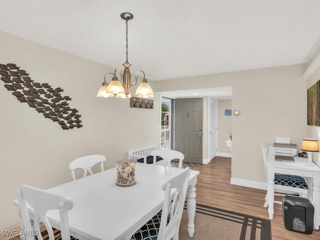 dining area featuring wood-type flooring and a chandelier