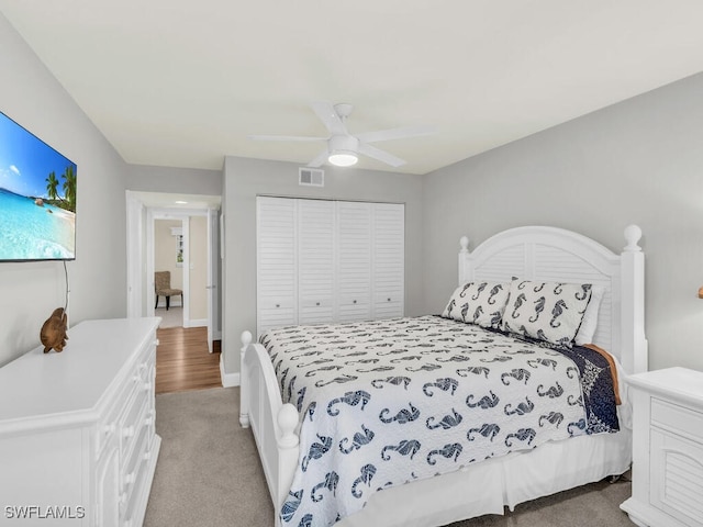 carpeted bedroom with ceiling fan and a closet