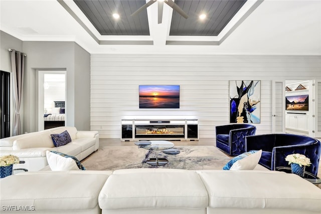 living room featuring ceiling fan, crown molding, and coffered ceiling