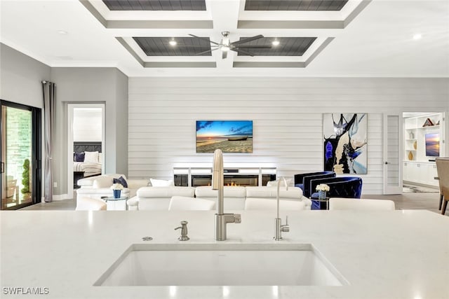 interior space featuring coffered ceiling, sink, ornamental molding, and beamed ceiling