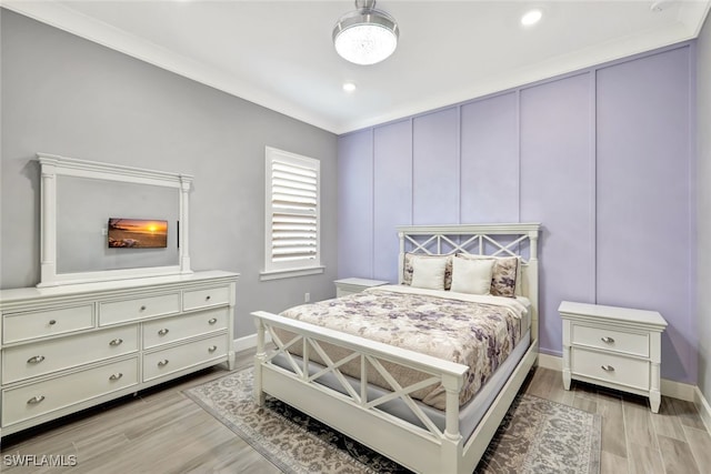 bedroom with ornamental molding and light hardwood / wood-style floors