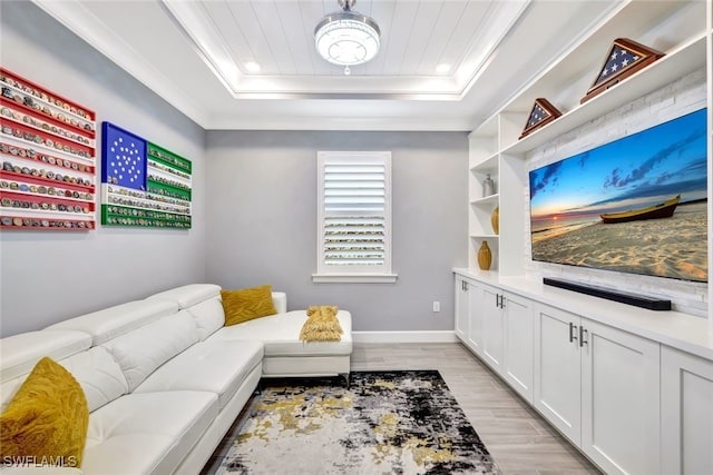 living room featuring ornamental molding, light hardwood / wood-style flooring, and a tray ceiling