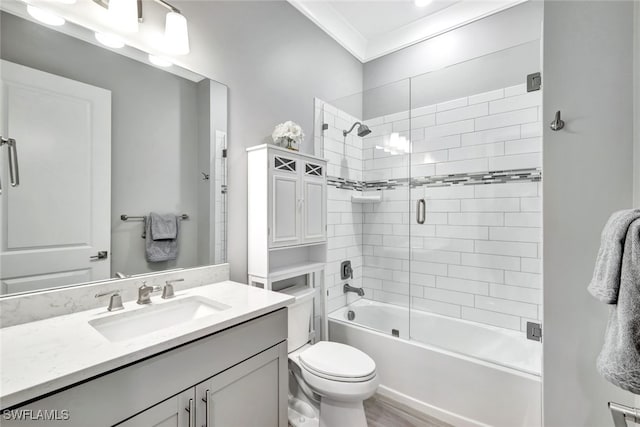 full bathroom featuring enclosed tub / shower combo, vanity, ornamental molding, and toilet