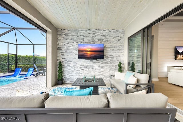 view of patio / terrace with glass enclosure, a pool, and an outdoor living space