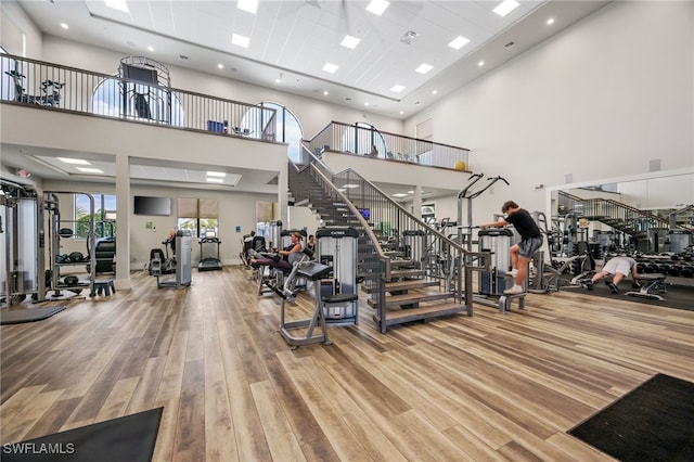 gym featuring hardwood / wood-style flooring and a high ceiling