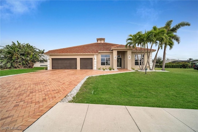 mediterranean / spanish home with a front yard and a garage