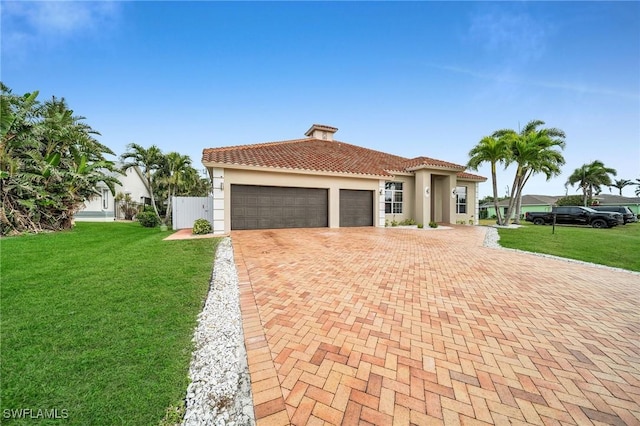 mediterranean / spanish-style house featuring a front yard and a garage