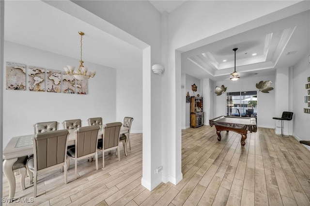 rec room with ceiling fan with notable chandelier, pool table, and a tray ceiling