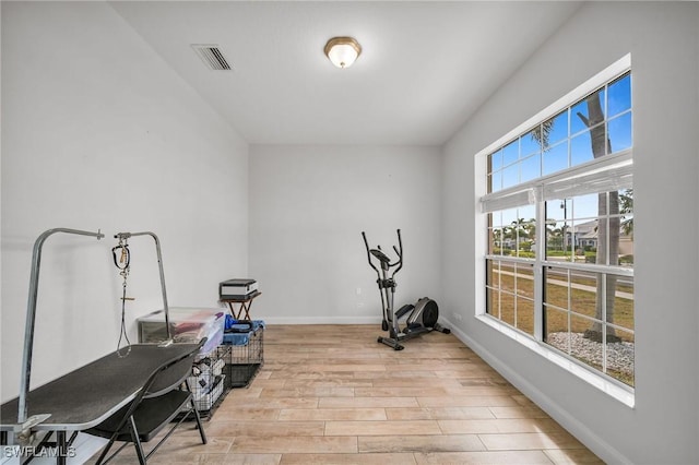 exercise room with light hardwood / wood-style flooring