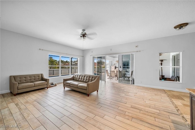 living room featuring ceiling fan and light hardwood / wood-style flooring