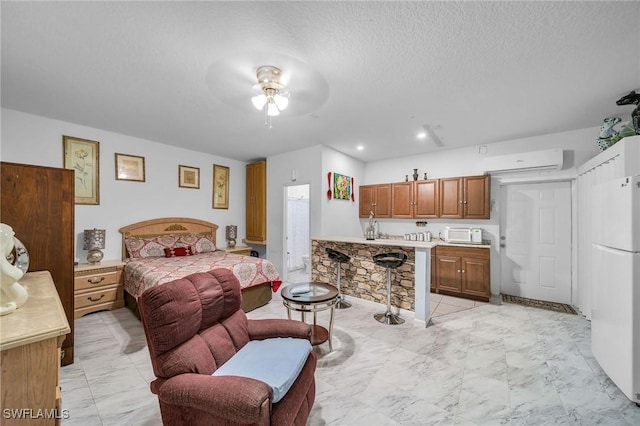 bedroom featuring ceiling fan, a wall mounted AC, white fridge, and a textured ceiling