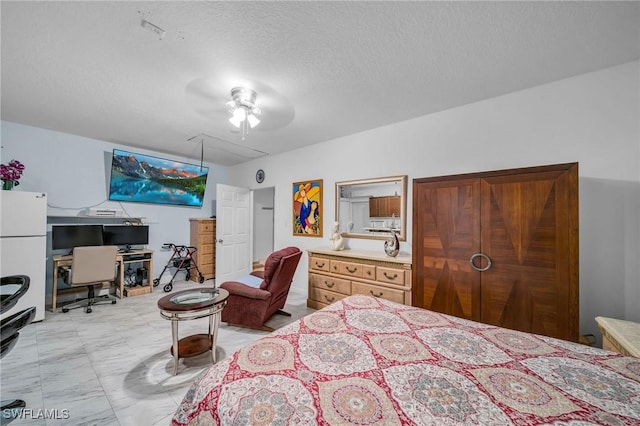 bedroom with ceiling fan, a textured ceiling, and white refrigerator