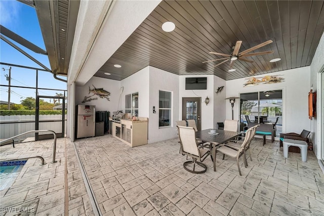 view of patio / terrace with ceiling fan, grilling area, glass enclosure, and area for grilling